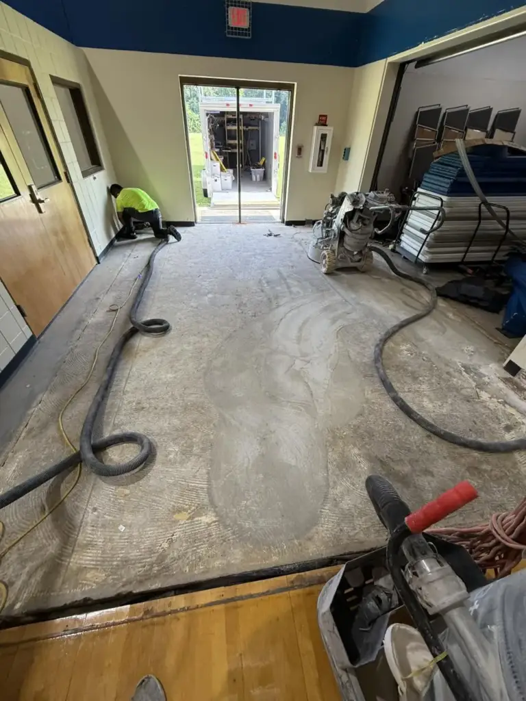 Hallway floor being ground and vacuumed before a coating
