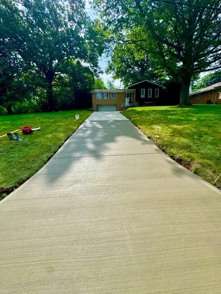 After: a broken, crumbling driveway replaced with new concrete.