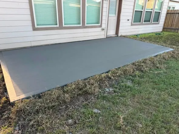 New grey concrete patio slab behind a home