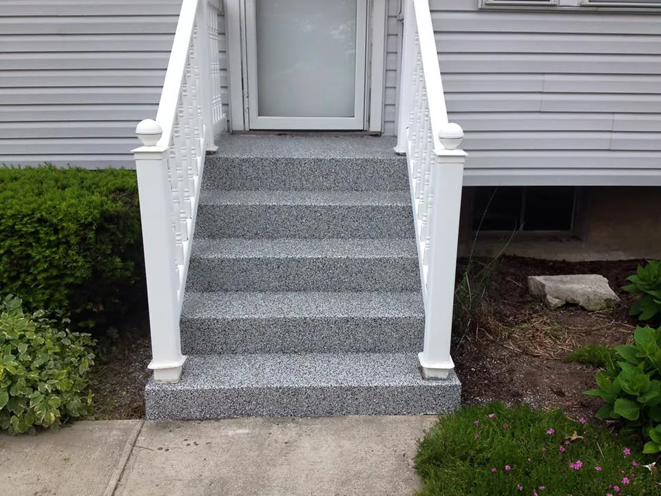 Concrete front steps with a new speckled finish and white railings