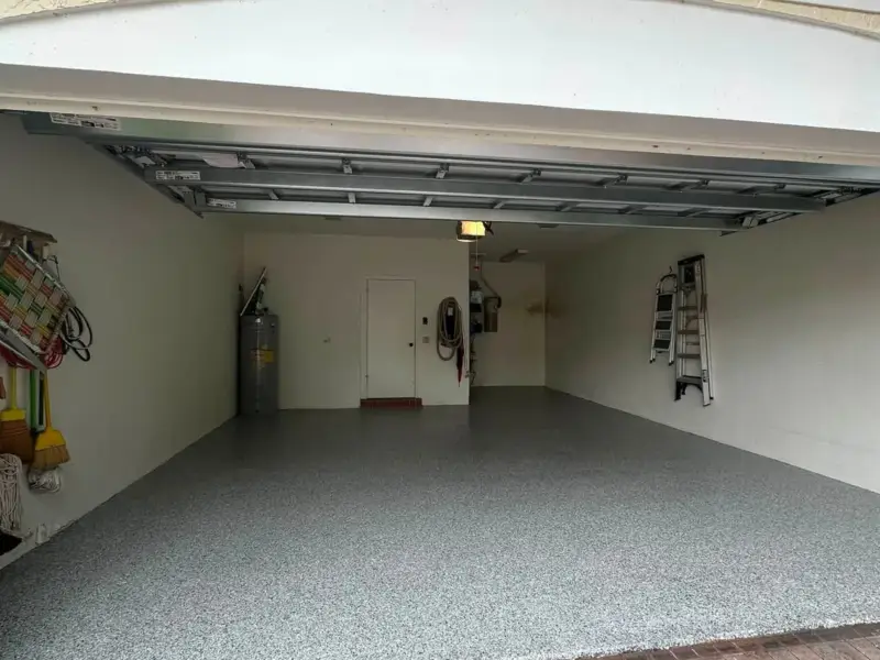 Single garage with a grey speckled floor coating and paver apron