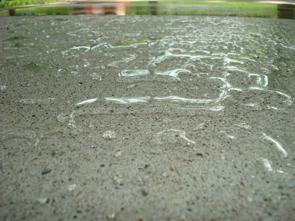 Close-up of water beading on a sealed concrete surface